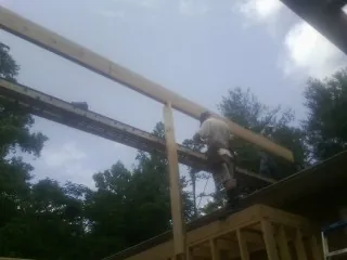 Carpenter setting a ridge beam over a new addition frame — Ice Dam Removal by Roofing Brothers in Entriken