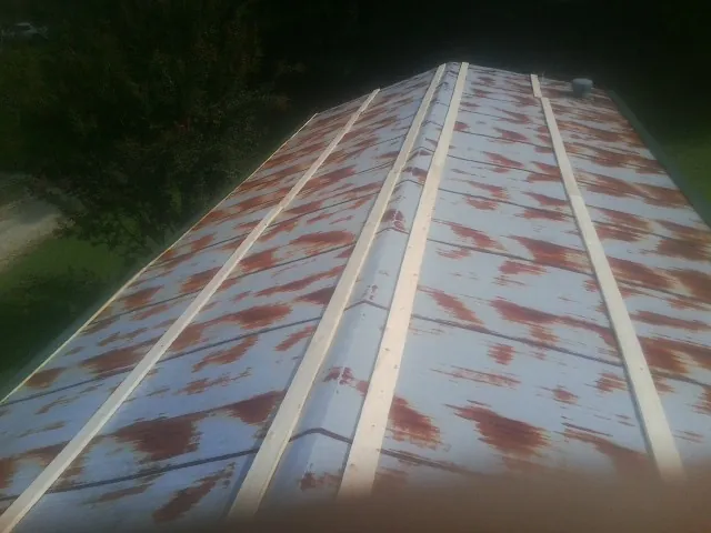 Rusted metal roof panels with new wood purlins before replacement — Storm Damage Roof Repair in Entriken by Roofing Brothers