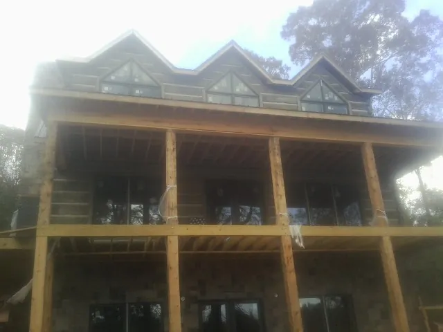 Dormers and porch framing on a large log home under construction — Roof Coating work by our crew in Entriken