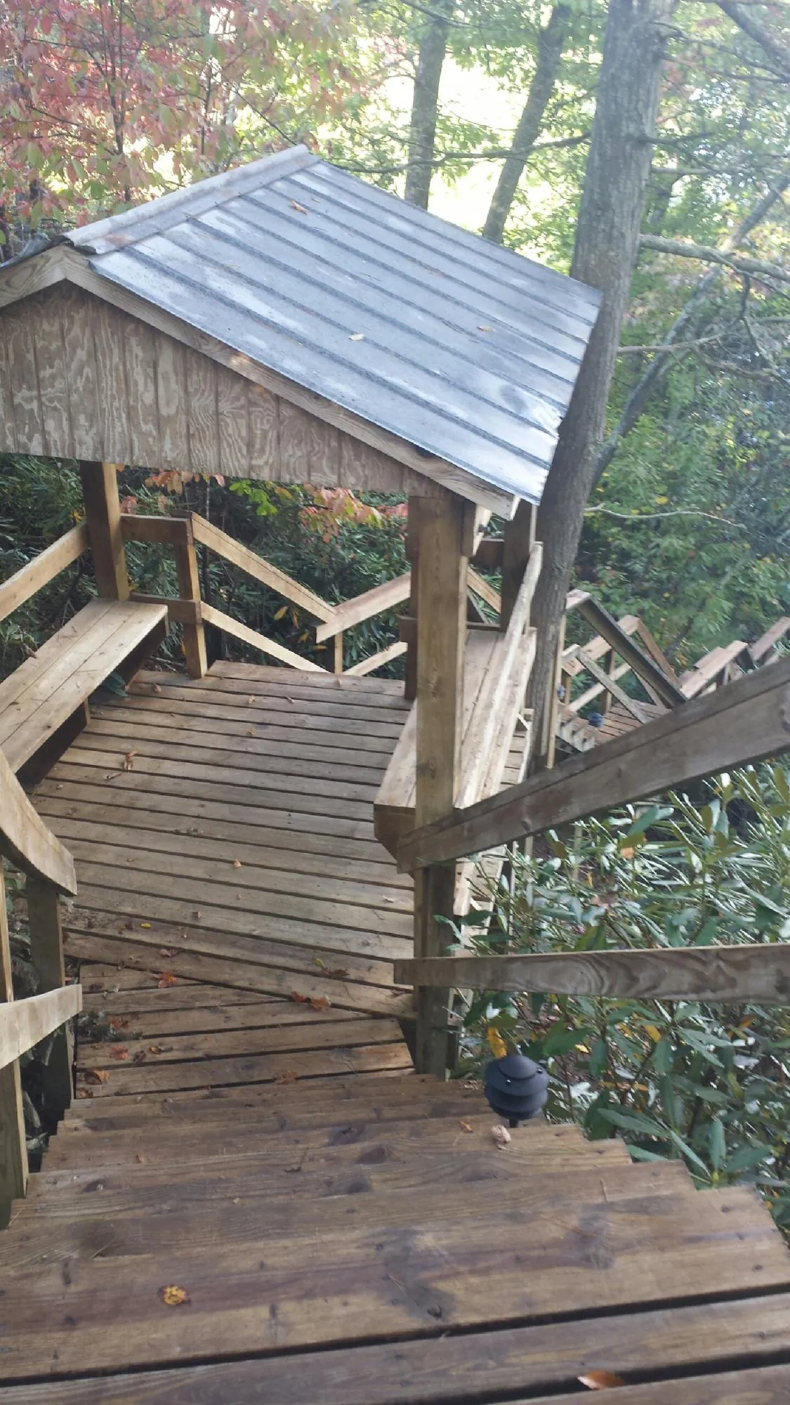 Metal roofed shelter over wooden steps on a wooded walkway — Skylight Repair & Installation work by our crew in Entriken